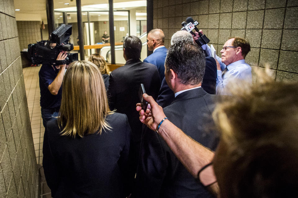 Nick Lyon, director of the Michigan Department of Health and Human Services, walks away as reporters ask him questions after leaving the courtroom where Genesee District Judge David J. Goggins bound Lyon's case over to Genesee Circuit Court for trial on Monday, Aug. 20, 2018 in Genesee District Court in Flint, Mich. Goggins ordered Lyons to stand trial for involuntary manslaughter in two deaths linked to Legionnaires' disease in the Flint area, the highest ranking official to stand trial as a result of the tainted water scandal. (Jake May/The Flint Journal via AP)