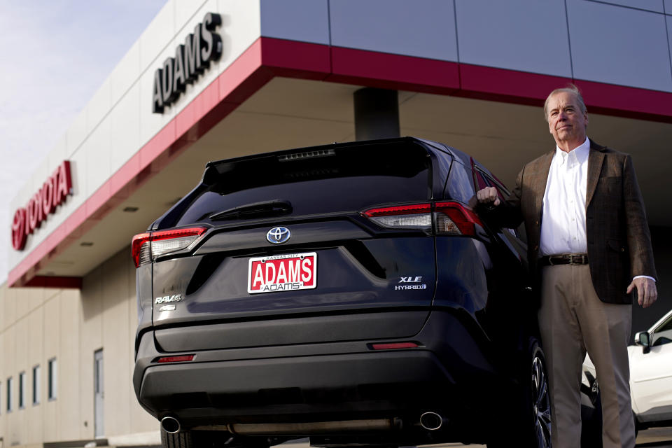 Scott Adams, owner of Adams Toyota, stands with a hybrid Toyota Rav4 at his dealership Tuesday, Dec. 12, 2023, in Lee's Summit, Mo. A typical hybrid costs somewhat more than its gasoline counterpart. A Toyota RAV4 hybrid with all-wheel-drive, for example, starts at $32,825, $1,600 more than a comparable gas version. (AP Photo/Charlie Riedel)