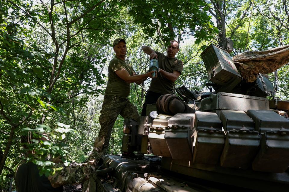 Ukrainian servicemen of the 30th Kostiantyn Ostrozkyi Separate Mechanized Brigade load shells into a T-80 main battle tank (REUTERS)