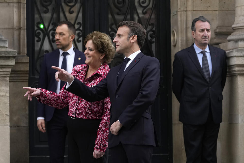 French President Emmanuel Macron and British ambassador to France Menna Rawlings gesture outside the Elysee Palace, Monday, April 8, 2024 in Paris. Sixteen soldiers from No 7 Company Coldstream Guards and 32 members of the Gendarmerie Garde Republicaine mount guard at the Elysee palace as British troops join French guards in a special ceremony at the Elysee Palace to celebrate 120 years of "entente cordiale" between the longtime rival powers. (AP Photo/Thibault Camus, Pool)