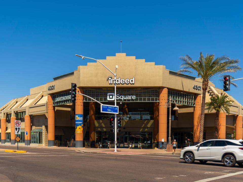 An adobe business building across an intersection on a day with clear blue skies