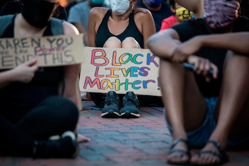 People attending a candlelight vigil for George Floyd, sponsored by Youth NXT and Durham Youth Climate Justice Initiative, sit and listen to people speak, perform songs and recite poems about dismantling racists systems in CCB Plaza in Durham, N.C. on Thursday, June 4, 2020.