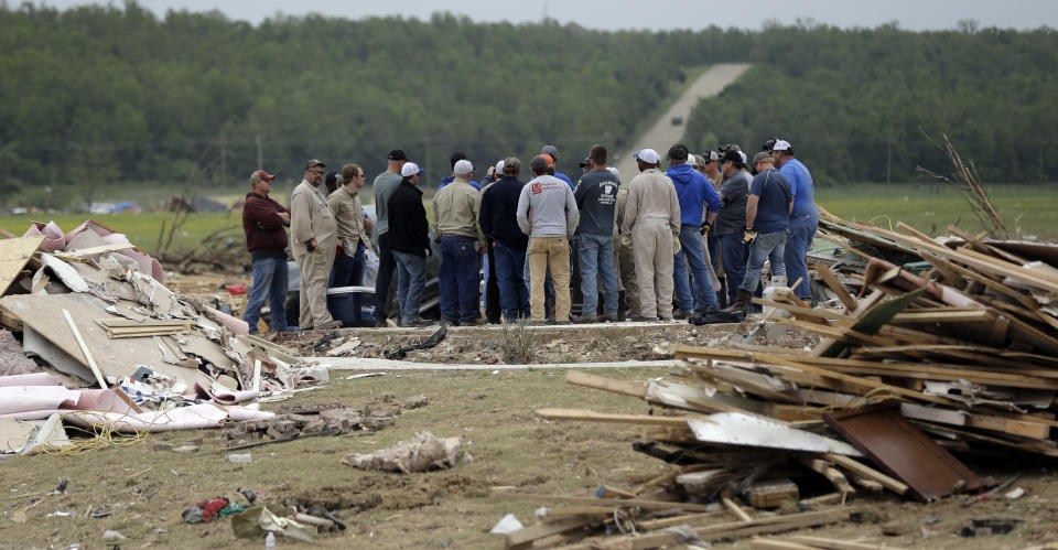 Volunteers gather on the slab of a home destroyed by Sunday's tornado, Tuesday, April 29, 2014, in Vilonia, Ark. A dangerous storm system spawned a chain of deadly tornadoes over three days. (AP Photo/Eric Gay)