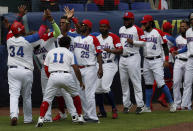 Dominican Republic baseman Juan Francisco, first left, is congratulated by his teammates after scoring a run against Venezuela during a final Olympic baseball qualifier game, in Puebla, Mexico, Saturday, June 26, 2021. (AP Photo/Fernando Llano)