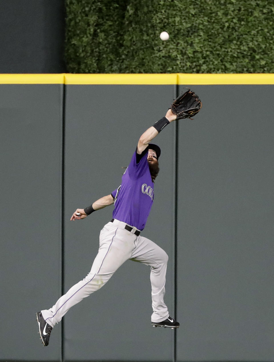 Colorado Rockies center fielder Charlie Blackmon leaps to make the catch on an RBI sacrifice fly by Houston Astros' Alex Bregman during the second inning of a baseball game Wednesday, Aug. 15, 2018, in Houston. (AP Photo/David J. Phillip)