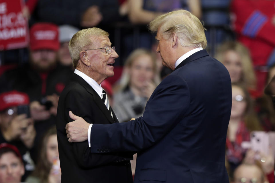 President Donald Trump greets former Notre Dame football coach Lou Holtz at a campaign rally at the Allen County War Memorial Coliseum in Fort Wayne, Ind., Monday, Nov. 5, 2018. (AP Photo/Michael Conroy)