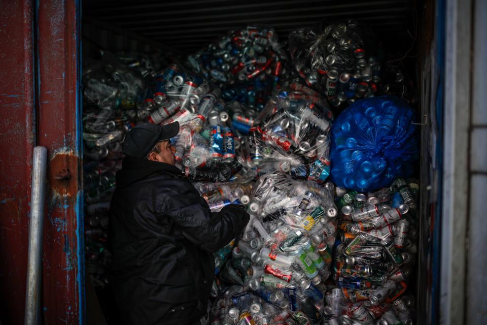 Manuel Rene Del Carmen organizes bags of recyclables in a shipping container at the Sure We Can recycling depot, Thursday, Feb. 27, 2020, in the Bushwick neighborhood of New York. He and others like him are called "bottle professionals" by some redemption centers employees who describe them as people who know by heart each recycling and trash pick-up route, who buy from other canners and who take the job seriously.