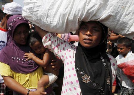 Rohingya and Bangladeshi migrants, who arrived in Indonesia by boat this week, leave a temporary shelter for new accommodation in Lhoksukon, Indonesia's Aceh Province May 13, 2015. REUTERS/Roni Bintang