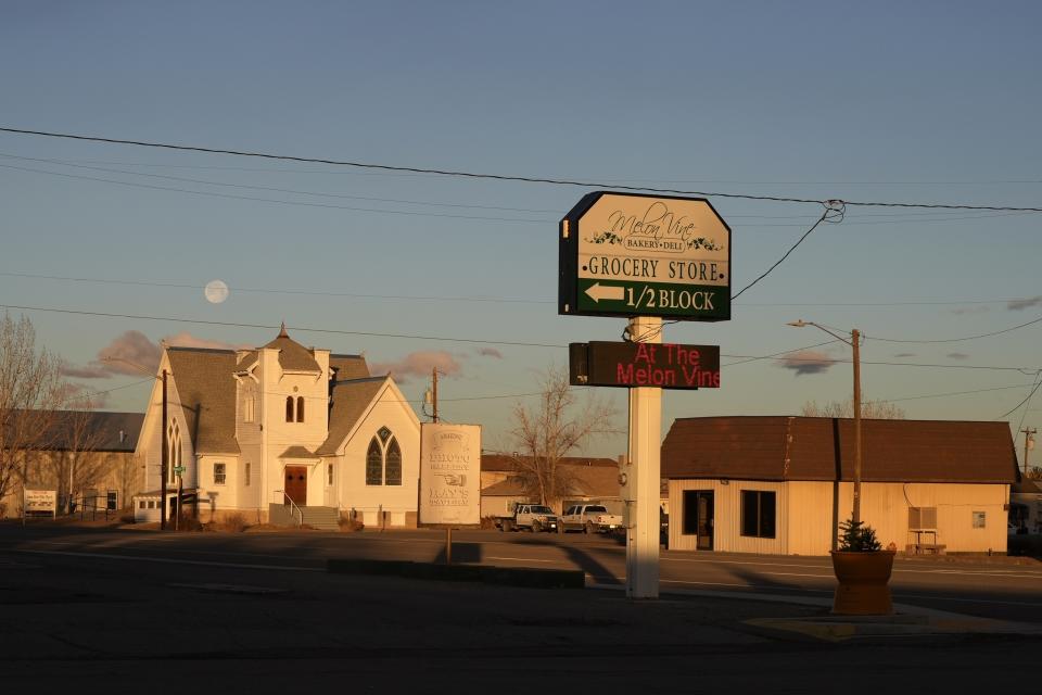 A grocery store sign is displayed near a church on Friday, Jan. 26, 2024, in Green River, Utah. An Australian company and its U.S. subsidiaries are eyeing a nearby area to extract lithium, metal used in electric vehicle batteries. (AP Photo/Brittany Peterson)