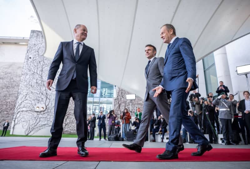 (L-R) German Chancellor Olaf Scholz welcomes French President Emmanuel Macron and Polish Prime Minister Donald Tusk following their arrival at the Chancellery. The so-called Weimar Triangle top level meeting is taking place against the backdrop of massive Franco-German differences over Ukraine policy. Michael Kappeler/dpa