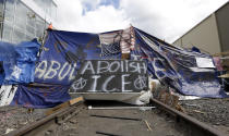 <p>A barricade crosses railroad track at a protest camp on property outside the U.S. Immigration and Customs Enforcement office in Portland, Ore., Monday, June 25, 2018. Law enforcement officers began distributing notices to vacate to demonstrators late Monday morning. The round-the-clock demonstration outside the Portland headquarters began June 17, 2018, and increased in size early last week, prompting officials to close the facility. (Photo: Don Ryan/AP) </p>