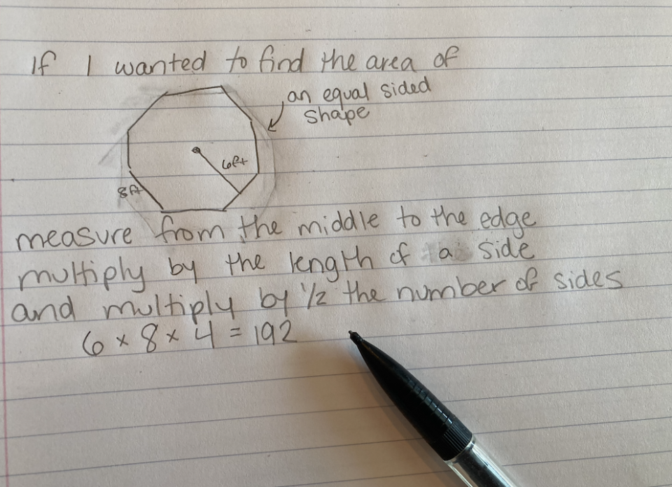 Handwritten math notes on finding the area of an equilateral octagon, with a pen resting on the paper