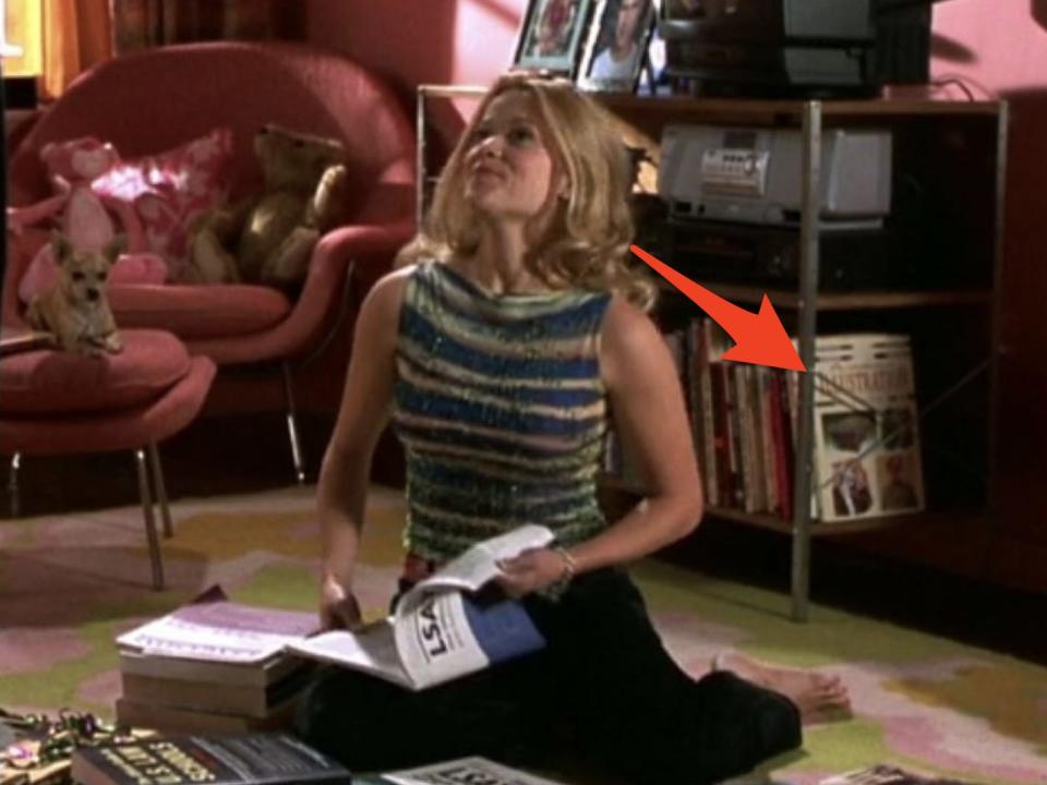 red arrow pointing at fashion books behind elle as she's studying for the lsats in legally blonde