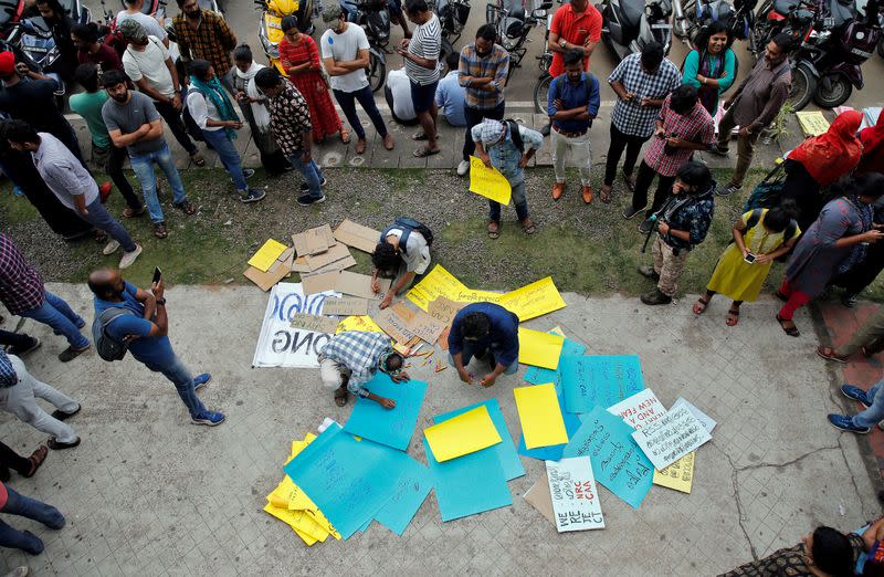 Demonstrators prepare placards before attending a protest march against a new citizenship law, in Kochi