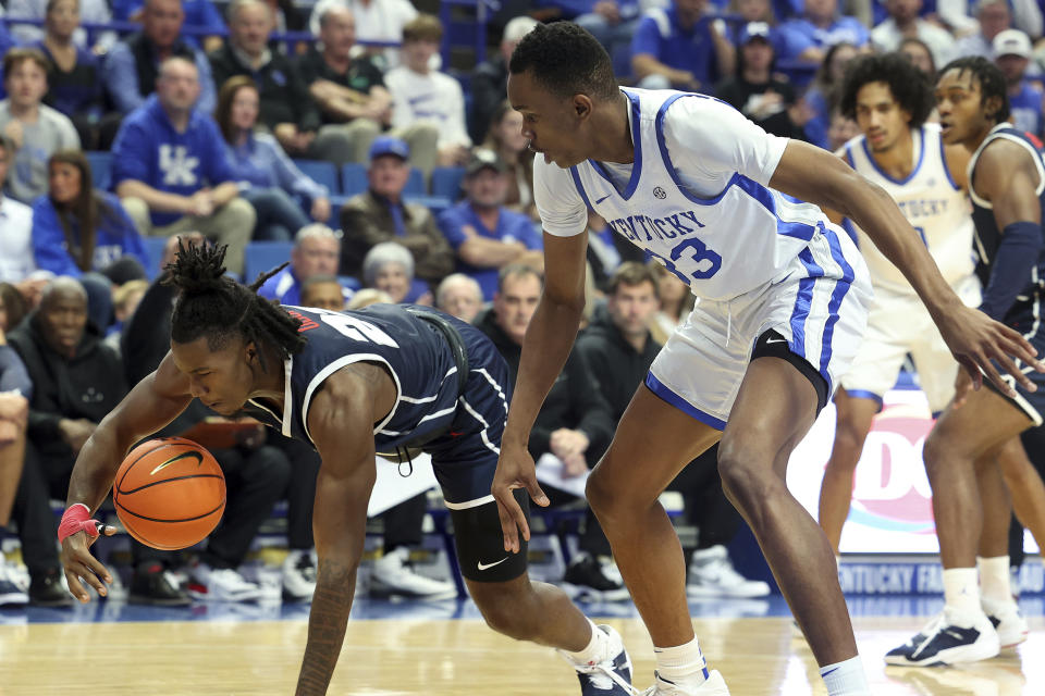 Howard's Shy Odom, left, dives for the ball next to Kentucky's Ugonna Onyenso (33) during the first half of an NCAA college basketball game in Lexington, Ky., Monday, Nov. 7, 2022. (AP Photo/James Crisp)