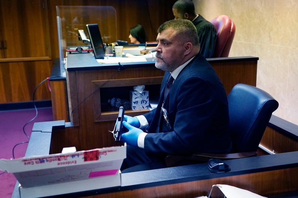 Oakland County Sheriff Lt. Tim Willis holds the gun Ethan Crumbley used to kill four students and injured six others and a teacher in November 2021 at Oxford High School, in court on Thursday, July 27, 2023, in Pontiac, Mich. Oakland County judge Kwame Rowe is hearing evidence starting Thursday to help him decide whether the teen who killed four students and injured six others at Oxford High School should be sentenced to prison without the chance of parole.