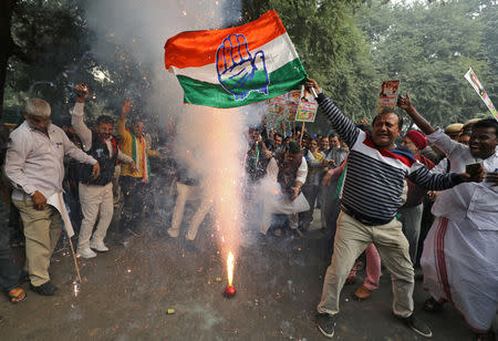 A supporter of India's main opposition Congress party waves the party's flag and celebrates after the initial poll results at the party headquarters in New Delhi, India, December 11, 2018. REUTERS/Anushree Fadnavis