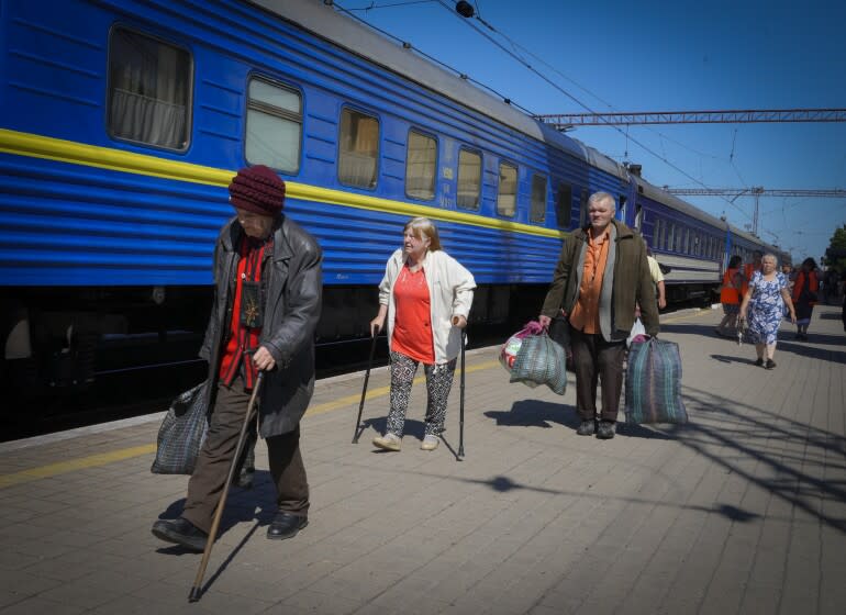 People walk toward the entrance of an evacuation train in Pokrovsk , Ukraine, on Saturday.