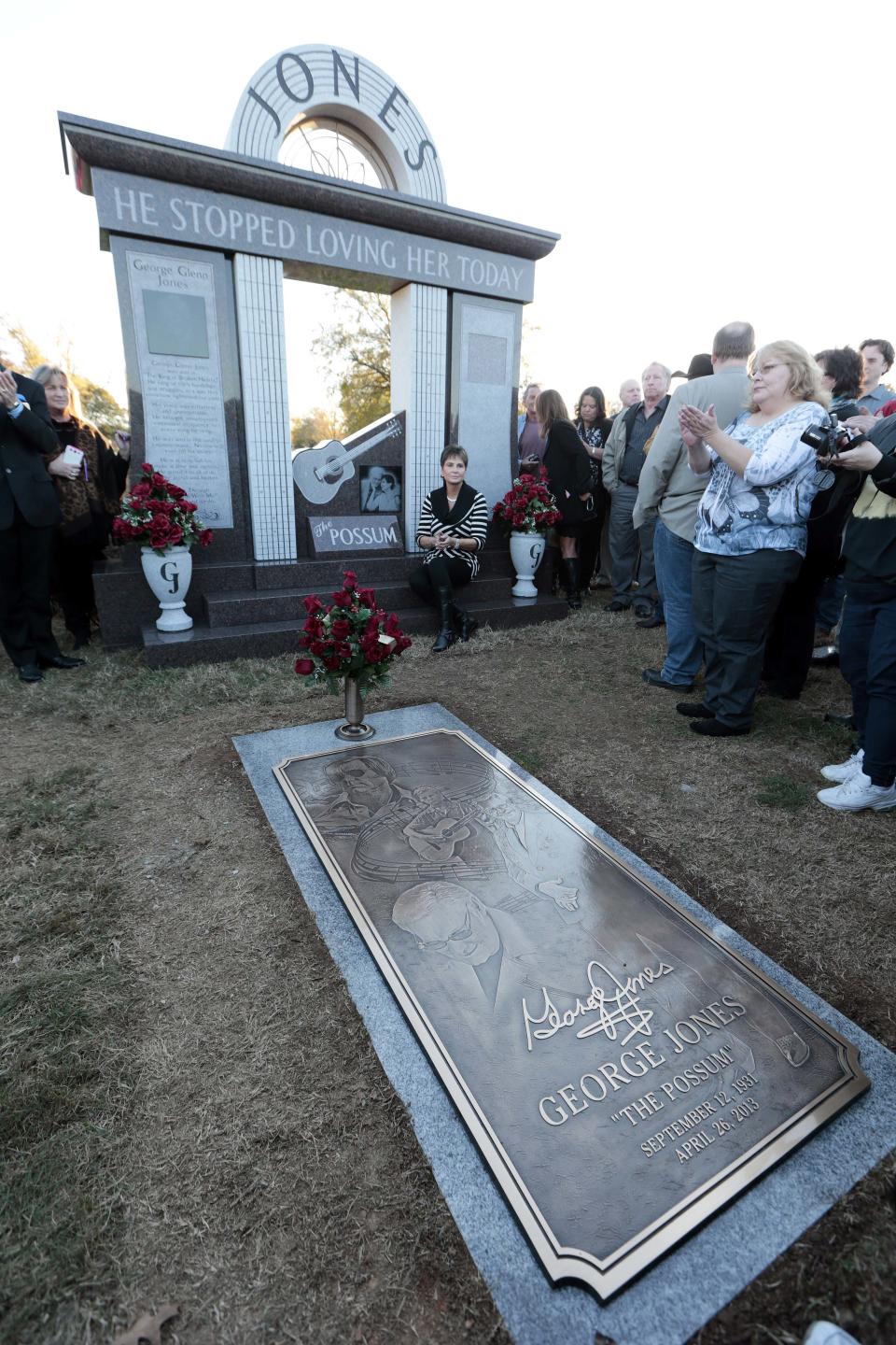 Nancy Jones, widow of country music star George Jones, listens as the Jones Boys band plays as she sits at the memorial unveiled at the late singer's grave on Monday, Nov. 18, 2013, in Nashville, Tenn. Nancy Jones spoke at the monument's dedication and announced a scholarship in her late husband's name at Middle Tennessee State University. George Jones died April 26. (AP Photo/Mark Humphrey)