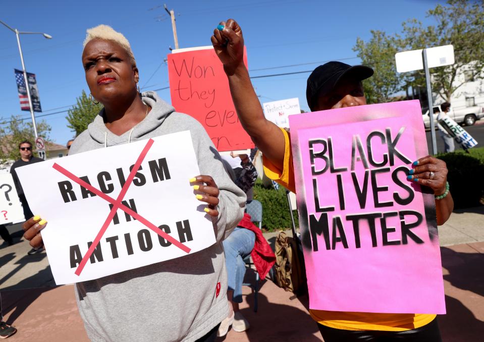 Kiora Hansen and Della Currie, from left, protest during a rally at Antioch police headquarters in Antioch, Calif., on Tuesday, April 18, 2023.