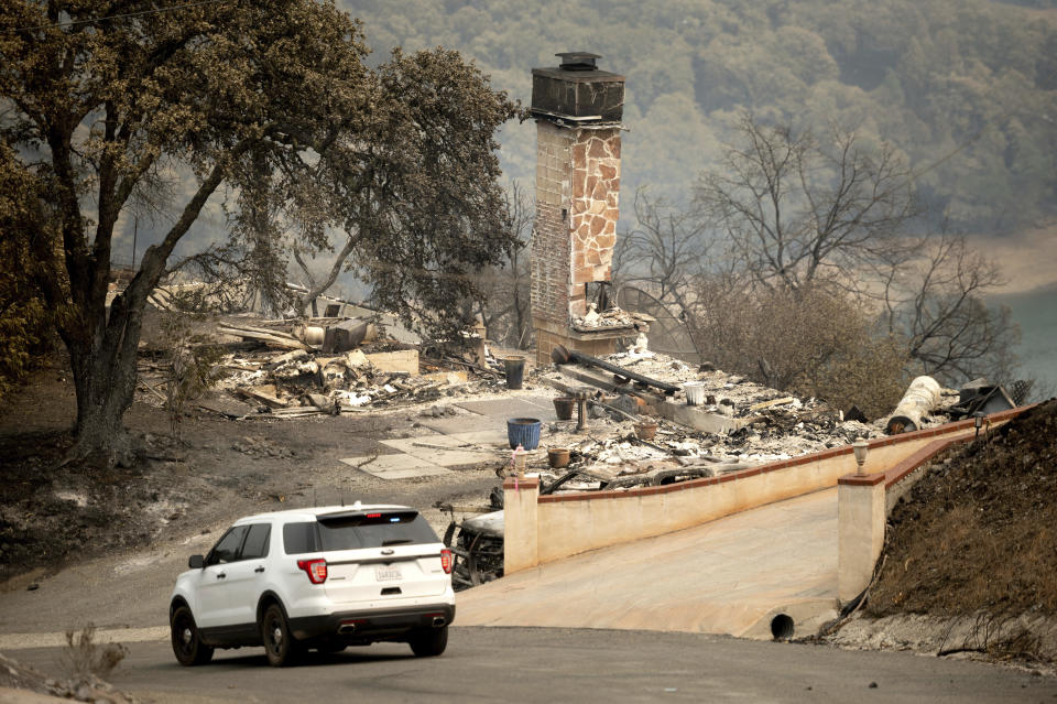 Following the LNU Lightning Complex fires, a sheriff's deputy patrols the evacuated community of Spanish Flat in Napa County, Calif. on Monday, Aug. 24, 2020. (AP Photo/Noah Berger)