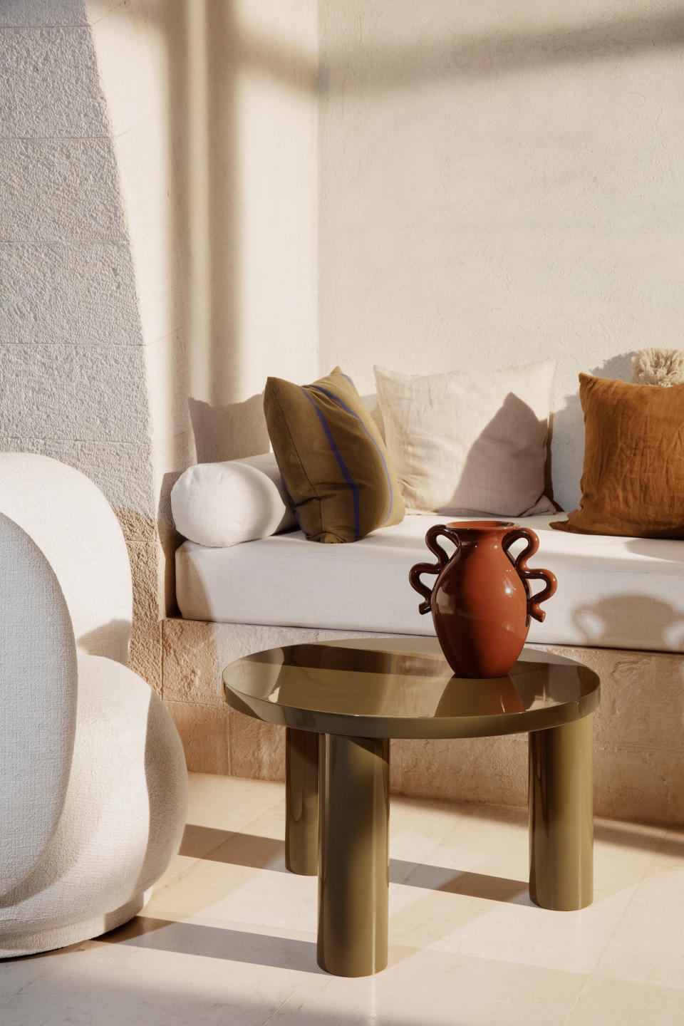 A living room with a dark red ceramic vase