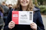 Lexi Menth of Seattle holds up her vote-by-mail ballot as supporters line up at a rally for U.S. Democratic 2020 presidential candidate Senator Elizabeth Warren at the Seattle Center Armory in Seattle