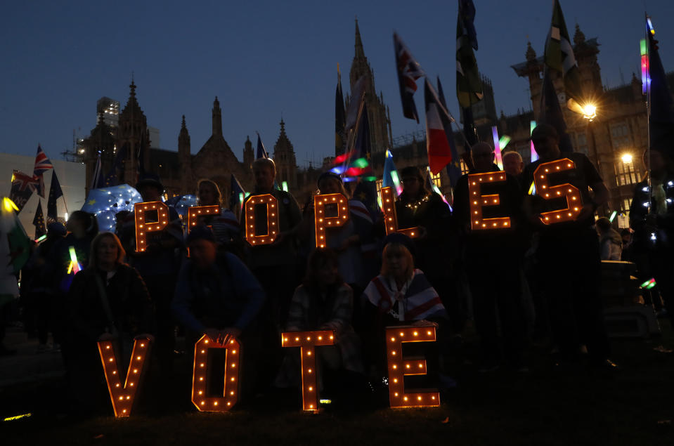 Remain in the European Union demonstrators hold up electrically lit letter asking for a 'People's Vote' opposite the Palace of Westminster in London, Wednesday, Feb. 27, 2019. British Prime Minister Theresa May says she will give British lawmakers a choice of approving her Brexit divorce agreement, leaving the EU March 29 without a deal, or asking to delay Brexit by up to three months. (AP Photo/Alastair Grant)