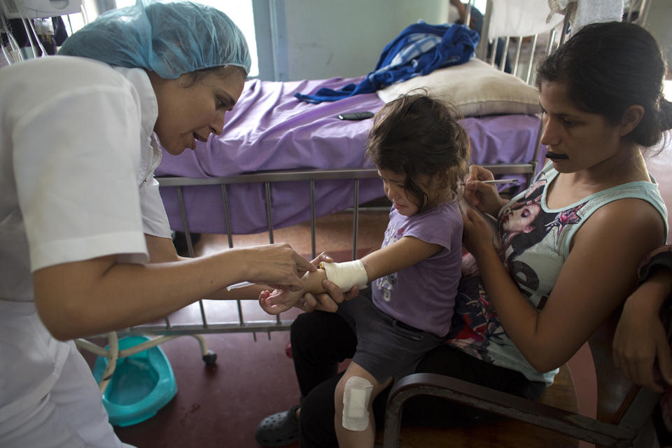 <p>Oriana Pacheo watches intently as a nurse injects antibiotics into the arm of her 3-year-old daughter Ashley, at University Hospital in Caracas, Venezuela, Aug. 23, 2016. With the hospital’s supply of the intravenous antibiotic exhausted, Ashley’s father scoured the city for vancomycin, combing pharmacies and hospital to no avail. But as he left one hospital, a man in a white coat pulled him aside and produced three vials from his pocket. (Ariana Cubillo/AP) </p>