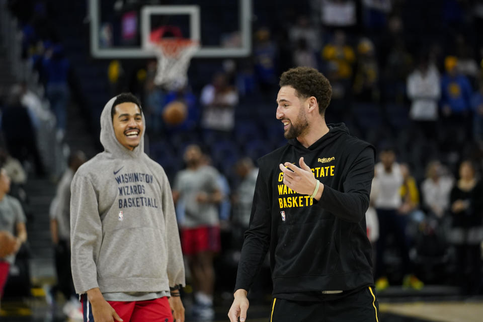 Golden State Warriors guard Klay Thompson, right, speaks to Washington Wizards guard Jordan Poole before an NBA basketball game Friday, Dec. 22, 2023, in San Francisco. (AP Photo/Godofredo A. Vásquez)