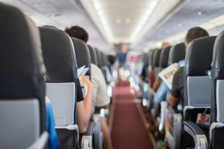 passenger seat, Interior of airplane with passengers sitting on seats and stewardess walking the aisle in background. Travel concept,vintage color