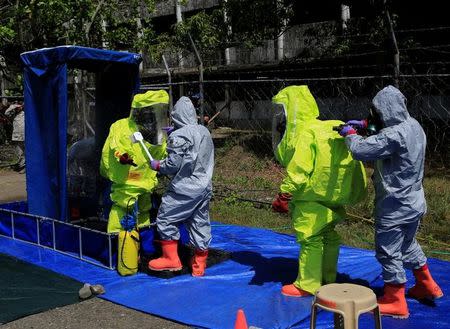 Filipino soldiers, member of a decontamination unit, check a mock rescuers, as a part of a chemical scenario during the Philippines and United States annual Balikatan (shoulder to shoulder) exercises inside the Fort Magsaysay military headquarters in Nueva Ecija province, north of Manila, Philippines May 12, 2017. REUTERS/Romeo Ranoco