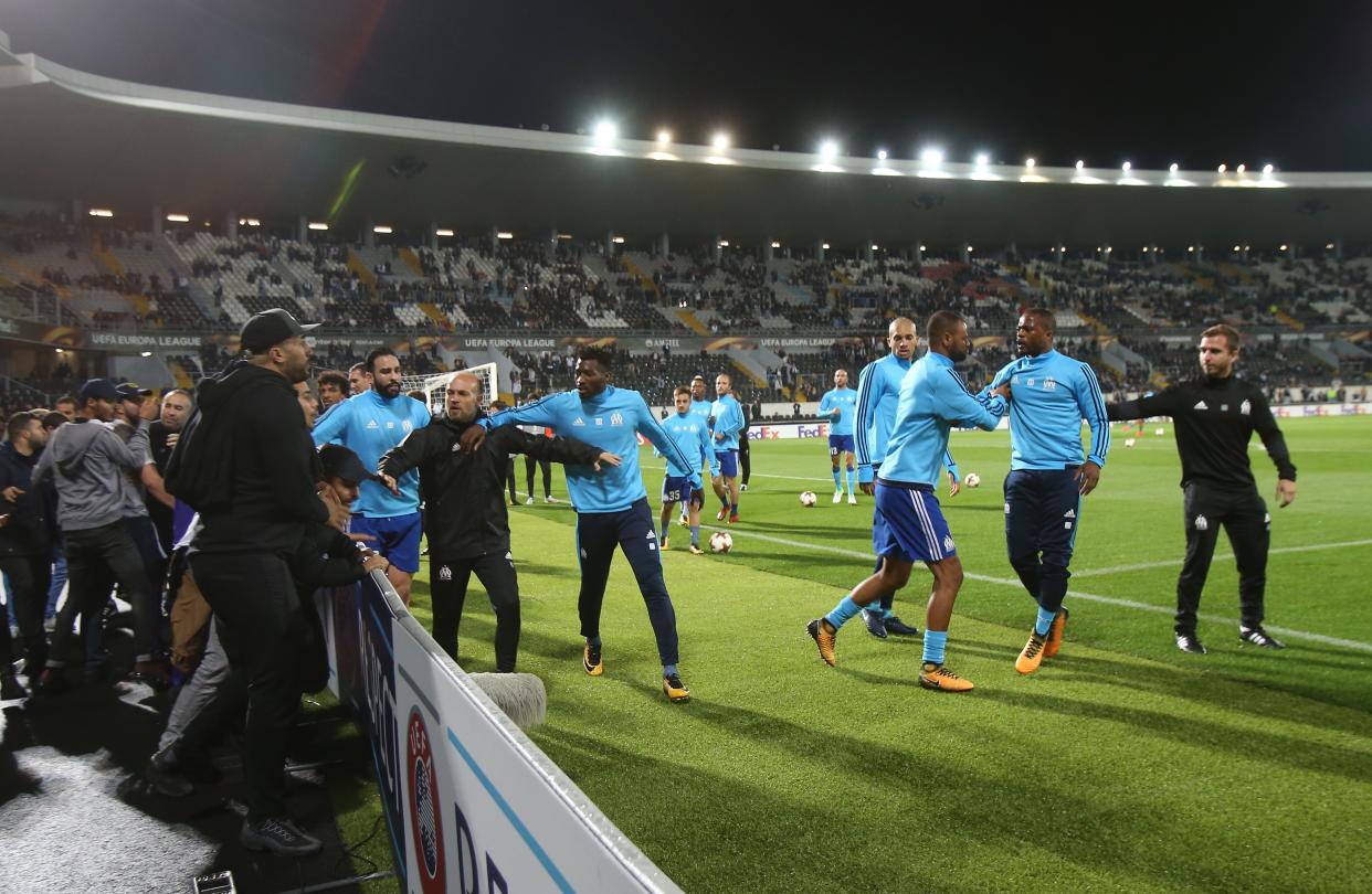 Patric Evra is restrained by teammates during a confrontation with fans before a Europa League match in Portugal.