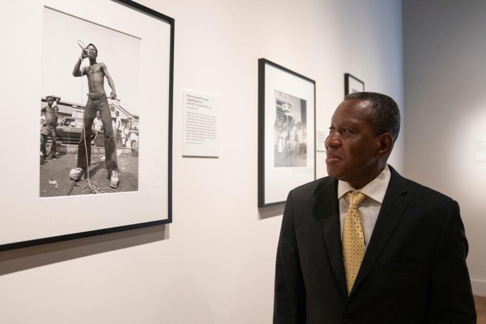 Curator of African art Nii Quarcoopome ponders one of his favorite photographs at the James Barnor exhibition. Quarcoopome, who grew up in Ghana, said the image resonates with him because it recalls the fashion of his youth. “We used to dress that way,” he said.