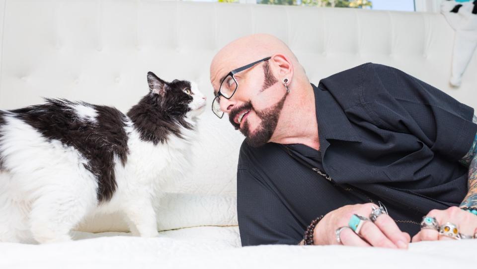 Jackson Galaxy boops noses with a black-and-white tuxedo cat. (Photo by Andrew Marttila.)