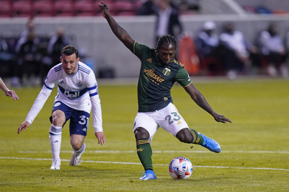 Portland Timbers forward Yimmi Chara (23) shoots as Vancouver Whitecaps midfielder Russell Teibert (31) looks on in the first half during an MLS soccer game Sunday, April 18, 2021, in Sandy, Utah. (AP Photo/Rick Bowmer)