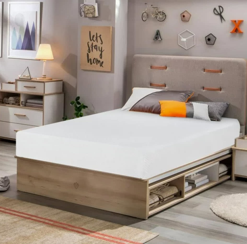 A modern bed with under-bed storage in a cozy bedroom setting with decor items