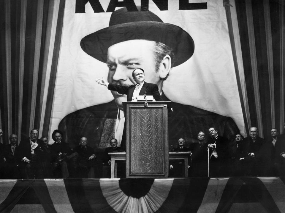 Charles Foster Kane (Orson Welles) makes a stirring campaign speech before a larger-than-life portrait of himself in a scene from Citizen Kane.