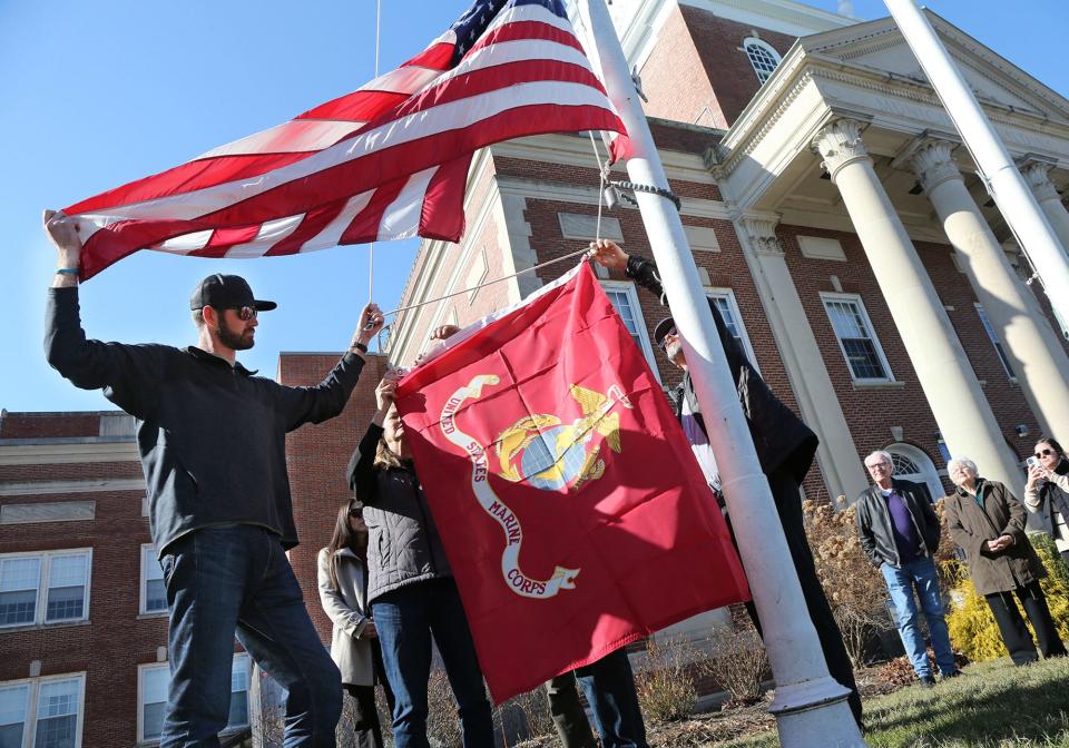 The family of the late Capt. Jack Casey, a helicopter pilot from Dover joins city leaders to raise the Marine flag with the American flag at half staff Saturday, Feb. 10, 2024. Casey died recently in a helicopter training flight crash in California.