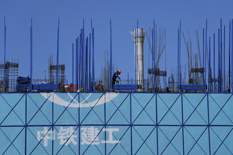 Workers install steel beams on a building under construction in Beijing on Oct. 26, 2021. China’s economic rebound from the coronavirus pandemic is stalling as President Xi Jinping’s government cracks down on surging corporate debt. (AP Photo/Andy Wong)