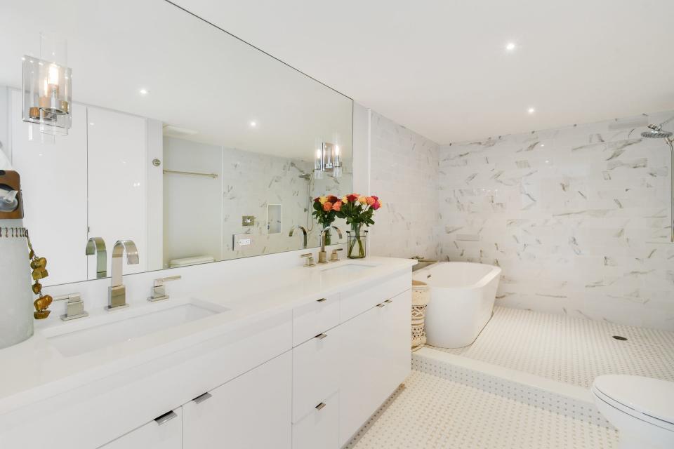The renovation of the primary bathroom added a “wet-room”-style shower with no door at one end. The area also is home to a freestanding tub.