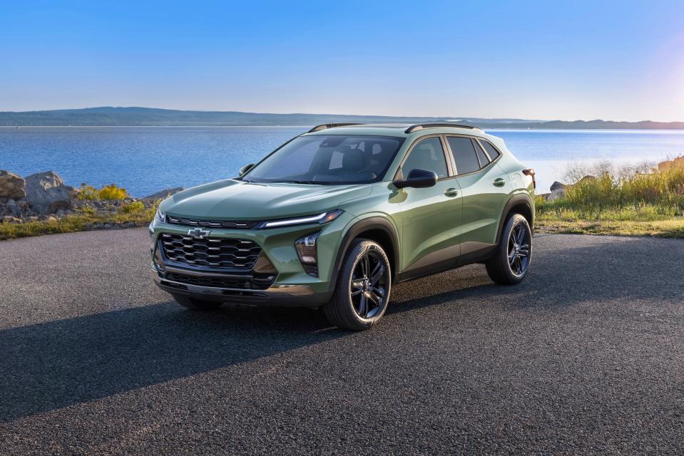 The 2024 Chevrolet Trax ACTIV in Cacti Green parked on a road in front of a lake. Pre-production model shown. Actual production model may vary. Available in spring 2023. Cacti Green exterior color late availability.