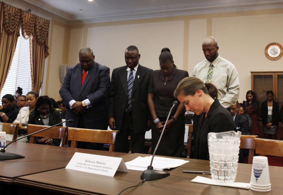 Daryl Parks, left, president of the National Bar Association, the Martin family lawyer, Benjamin Crump, and Trayvon Martin's parents, Tracy Martin, and Sybrina Fulton, stand during a moment of prayer for Trayvon Martin during a House Judiciary Committee Democrats' briefing on racial profiling and hate crimes on Capitol Hill, in Washington, on Tuesday, March 27, 2012. In front is Rebecca Monroe, with the Department of Justice. (AP Photo/Jacquelyn Martin)