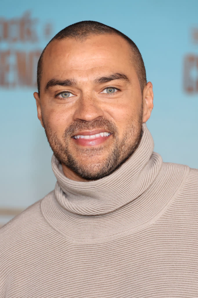 A close-up of Jesse smiling while wearing a turtleneck at an event