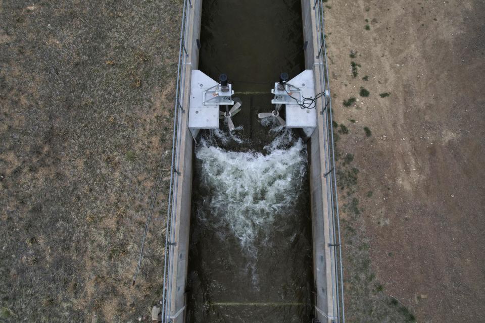 Water flows through an irrigation canal with a turbine at Ralston Reservoir in Arvada Colo. on Thursday, April 13, 2023. Emrgy, a business that places small turbines in irrigation canals to generate electricity, has raised $18.4 million to scale up its technology and generate carbon-free hydropower. (AP Photo/Brittany Peterson)