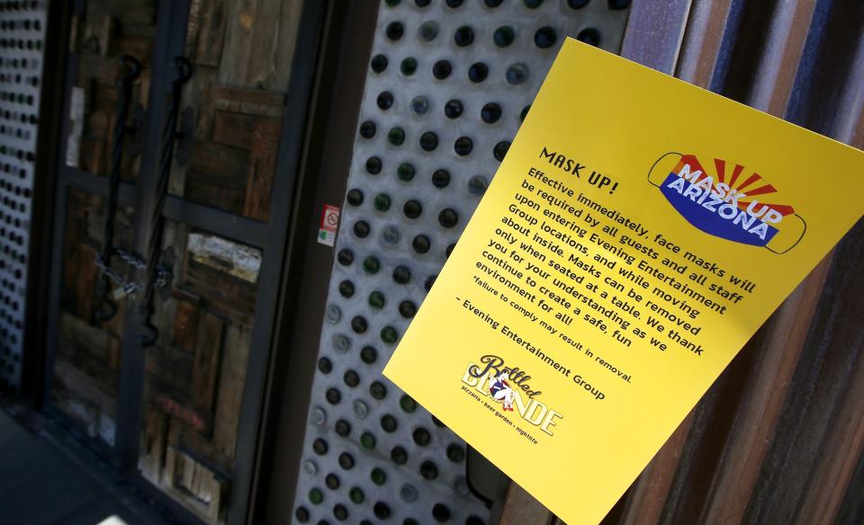 Bottled Blonde, one of the restaurant bars closed for the next 30 days due to the surge in coronavirus cases, has a posted rules sign but also has a padlocked front door Tuesday, June 30, 2020, in Scottsdale, Ariz. (AP Photo/Ross D. Franklin)