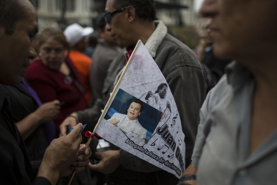 A man holds a picture of Mexican songwriter and singer Juan Gabriel during the Memorial at Palacio de Bellas Artes.