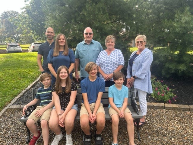 Members of the Bahler Family sit and stand Thursday, Sept. 7, 2023, in the new Butterfly Garden at Silver Park in Alliance. The family sponsored the bench on which the youngsters are sitting in honor of Wanda Bahler.