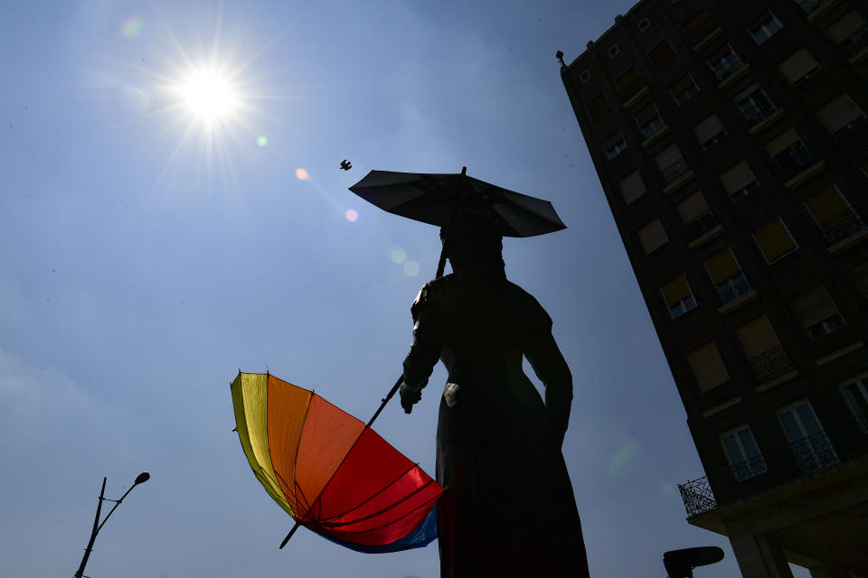 A rainbow colored umbrella is attached to a statue before a gay pride parade in Budapest, Hungary, Saturday, July 24, 2021. Hungary's government led by right-wing Prime Minister Viktor Orban passed a law in June prohibiting the display of content depicting homosexuality or gender reassignment to minors, a move that has ignited intense opposition in Hungary while EU lawmakers have urged the European Commission to take swift action against Hungary unless it changes tack. (AP Photo/Anna Szilagyi)