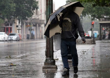 A man walks through rain in the French Quarter caused by Hurricane Barry in New Orleans